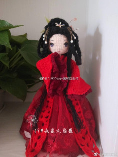 black haired doll wearing red crochet pattern