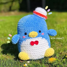 Blue penguin crochet pattern, white belly wearing a hat.