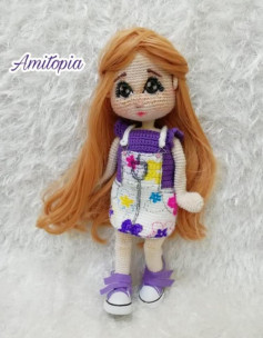 brown haired doll wearing purple crochet pattern