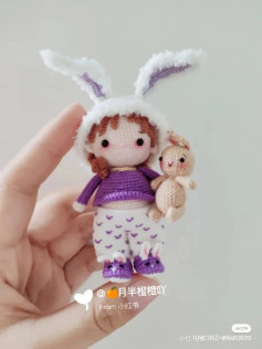 crochet pattern doll wearing rabbit ears hat, purple shirt.