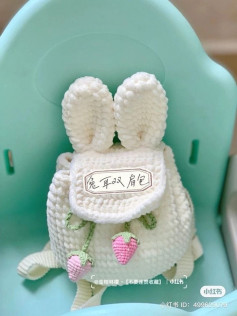 crochet pattern rucksack with rabbit ears decorated with strawberries.