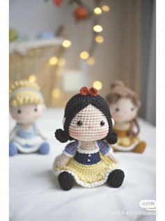 crochet pattern Snow White wears a yellow dress with a bow on her head.