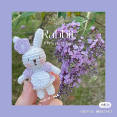 crochet pattern white rabbit wearing white dress, ears tied with flower bows.
