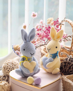 Gray rabbit crochet pattern, yellow rabbit hugging heart.