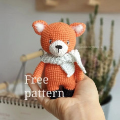Orange bear crochet pattern with white scarf.