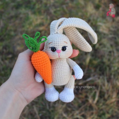 Ушастый кролик крючком обнимает морковь