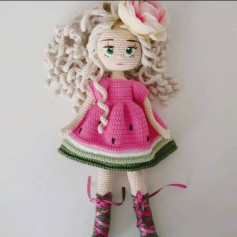 Вязаная крючком белая кукла в розовом платье.