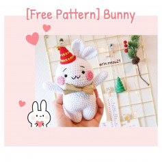 White rabbit crochet pattern wearing red hat, pink cheeks.