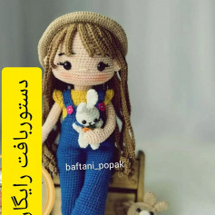 brown haired doll wearing a hat, yellow shirt, blue overalls, holding a white rabbit, crochet pattern
