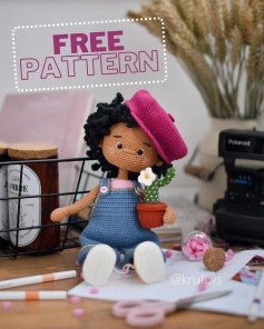 free crochet pattern black hair wearing pink hat wearing blue overalls
