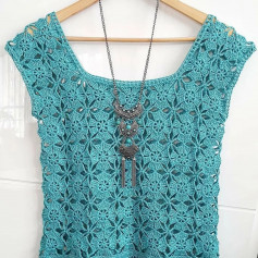 free crochet pattern sweater decorated with blue and white flowers.