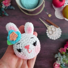 free crochet pattern white rabbit with short ears, blue bow, pink nose.