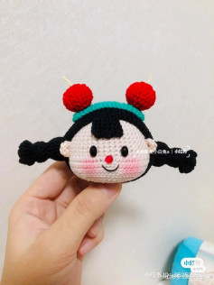 Black haired girls head, wearing a cherry hat