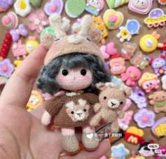 The doll wears a crochet deer pattern