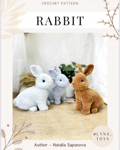 White, brown, gray rabbits are sitting.