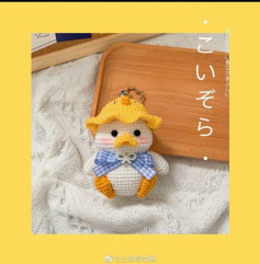 White duck keychain with yellow hat, blue bow, crochet pattern