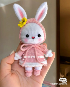 White rabbit wearing pink dress, pink hat, yellow flower on head, crochet pattern