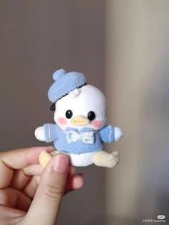 Crochet pattern for a white duck wearing a blue hat and blue shirt.