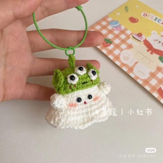 Crochet pattern for a keychain with a ghost wearing a 3-eyed monster hat