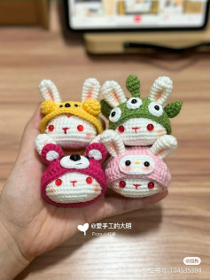 Crochet pattern for a rabbit head wearing a 3-eyed monster hat, a strawberry bear hat, a pink pig hat, and a dog hat.