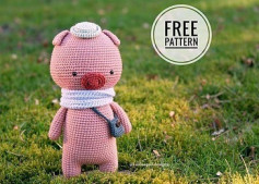 Crochet pattern of a pink pig wearing a scarf and hat and carrying a crossbody bag