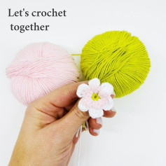 Crochet pattern of white five-petal flower, pink pistil.