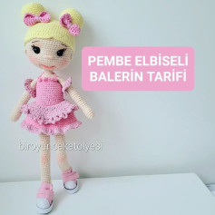 Pembe fiyonklu pembe bir elbise giyen sarı saçlı bir bebek için tığ işi modeli.