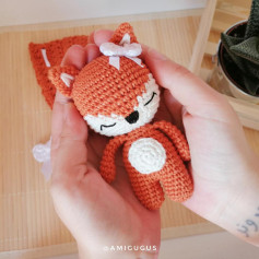 Crochet pattern of a sleeping fox wearing a bow
