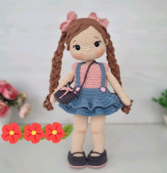 Crochet pattern for doll with brown hair, wearing a blue dress, carrying a crossbody bag