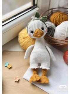 Crochet pattern for a white duck with a yellow beak wearing a bow