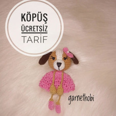 Pembe elbise giyen bir köpeğin tığ işi modeli.