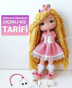 Pembe elbiseli ve sarı saçlı bebek için tığ işi modeli.