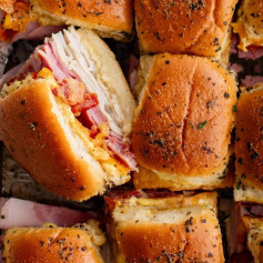 These Baked Club Sliders are super easy to make with layers of deli turkey, ham, and bacon stuffed between Hawaiian Rolls and smothered in garlic herb butter!⁠