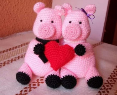 Dos cerditos tejidos con corazón rojo, perfectos para San Valentín.