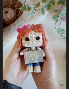 Muñeca de ganchillo con libro de aventuras: una obra maestra hecha a mano.