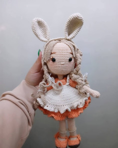Muñeca de ganchillo con orejas de conejo y vestido colorido