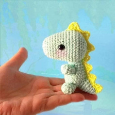 Patrón de amigurumi: Pequeño dinosaurio tejido a crochet con detalles adorables.