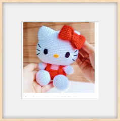 Patrón de ganchillo para crear un adorable gato con lazo rojo