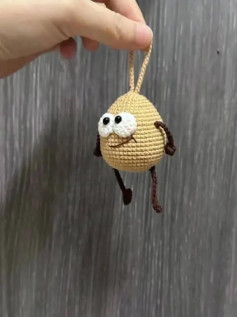 Pequeño muñeco amigurumi tejido a crochet con expresión divertida