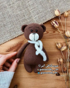 عروسک خرس قهوه‌ای با شال گردن سفید بافتنی