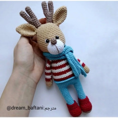 الگوی قلاب‌بافی عروسک گوزن با شال آبی و لباس راه‌راه