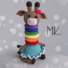 Вязаная игрушка жирафа с радужной шеей и синей юбкой