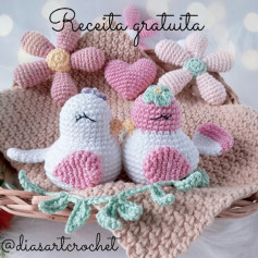 Pássaros de crochê amorosos em jardim florido