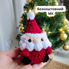 Вязаний Санта Клаус на тлі новорічної ялинки