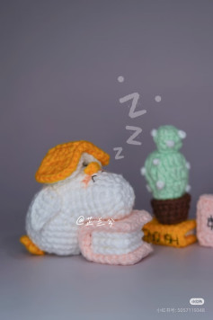 Crochet Penguin Sleeping on Books with Cactus