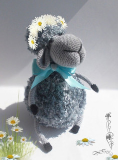 Вязаная овечка с цветочным венком и голубой лентой