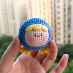 Búp bê béo tròn dễ thương với bộ đồ len xanh và tóc vàng