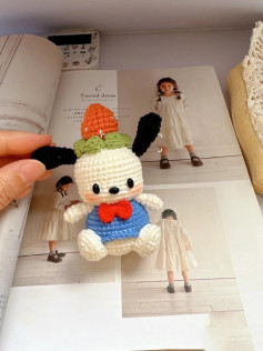 Móc len hình chú chó dễ thương với nơ đỏ và áo xanh.