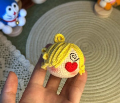 Búp bê móc len hình đầu nhân vật với trái tim đỏ