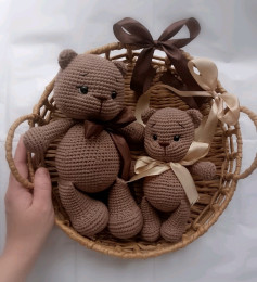 Вязані гачком іграшкові ведмедики у кошику з бантами